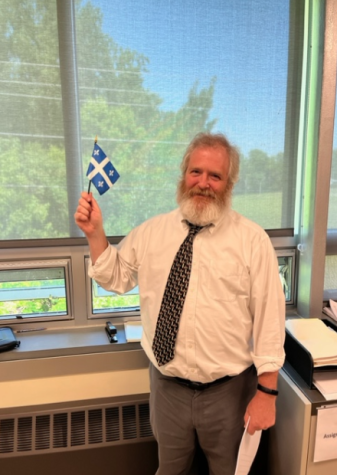 Christian Frenette in his classroom waving the Quebecois flag. (Photo/Patrick Sawyer)
